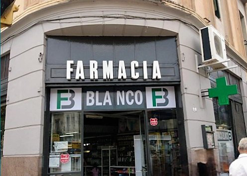 Fachada de Farmacia Blanco en Sarmiento 47, esquina República de Israel, con el cartel de la farmacia y la cruz verde.